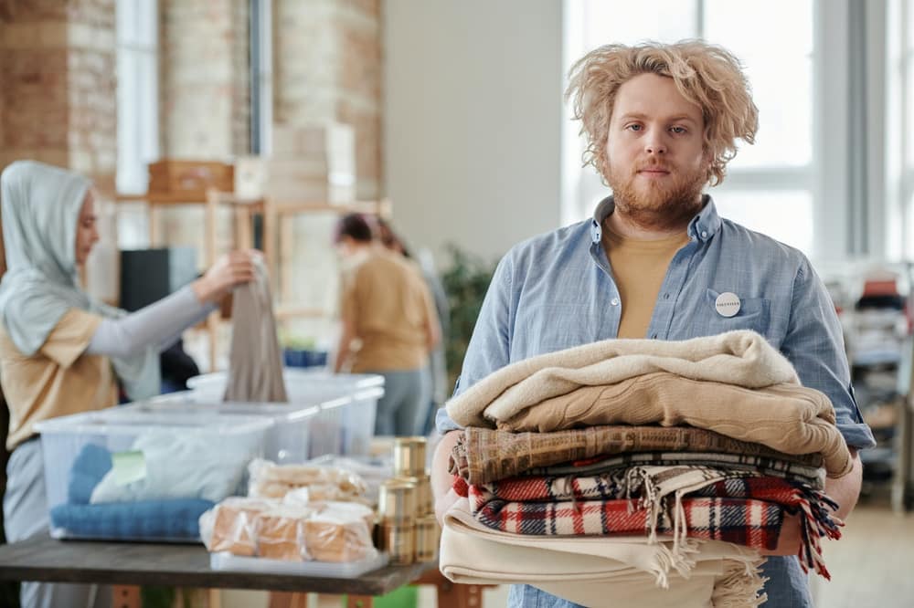 Volunteer carrying a stack of donated blankets